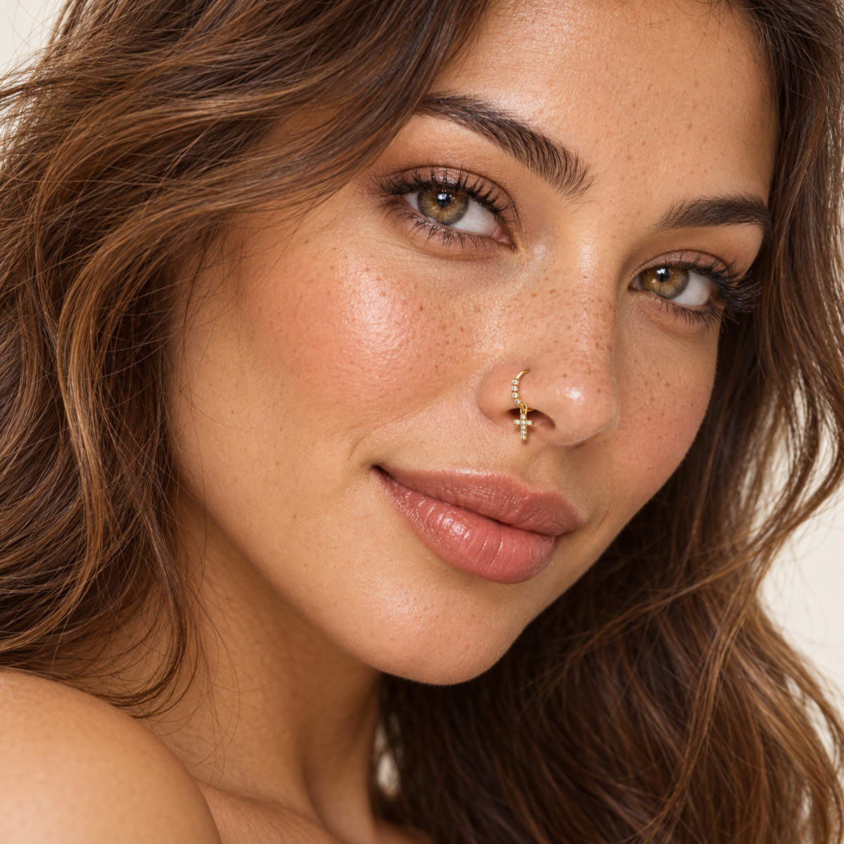 Model wearing gold 90 crystal cross hoop nose ring