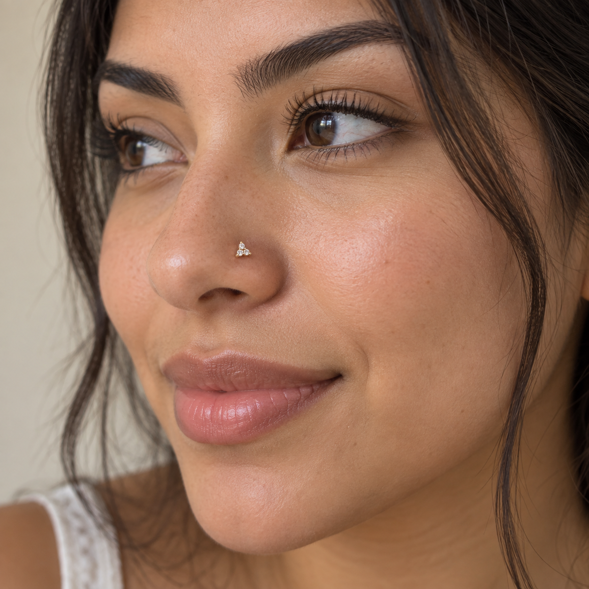 Model wearing JOAJOA 10 petite gold three-stone nose stud