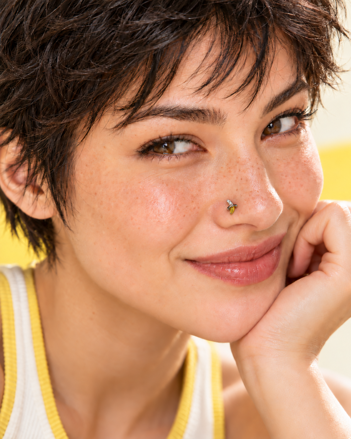 JOAJOA Style 134 tiny peeled banana L-shape nose stud worn by playful model