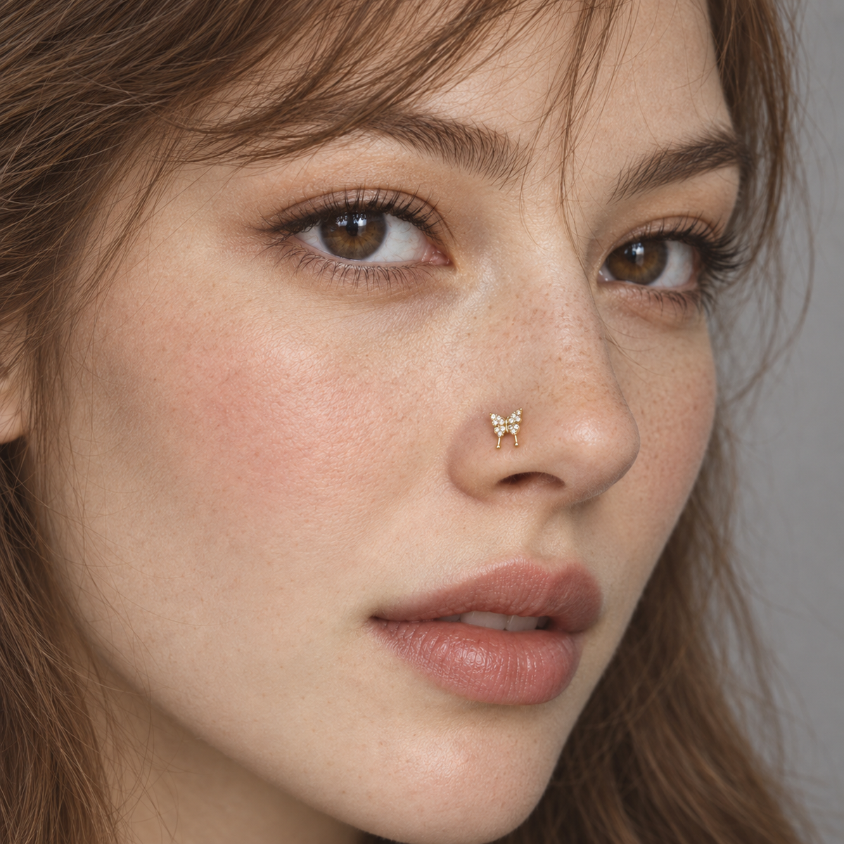 JOAJOA 143 gold crystal Swallowtail Butterfly L-shaped nose stud worn by freckled brunette model