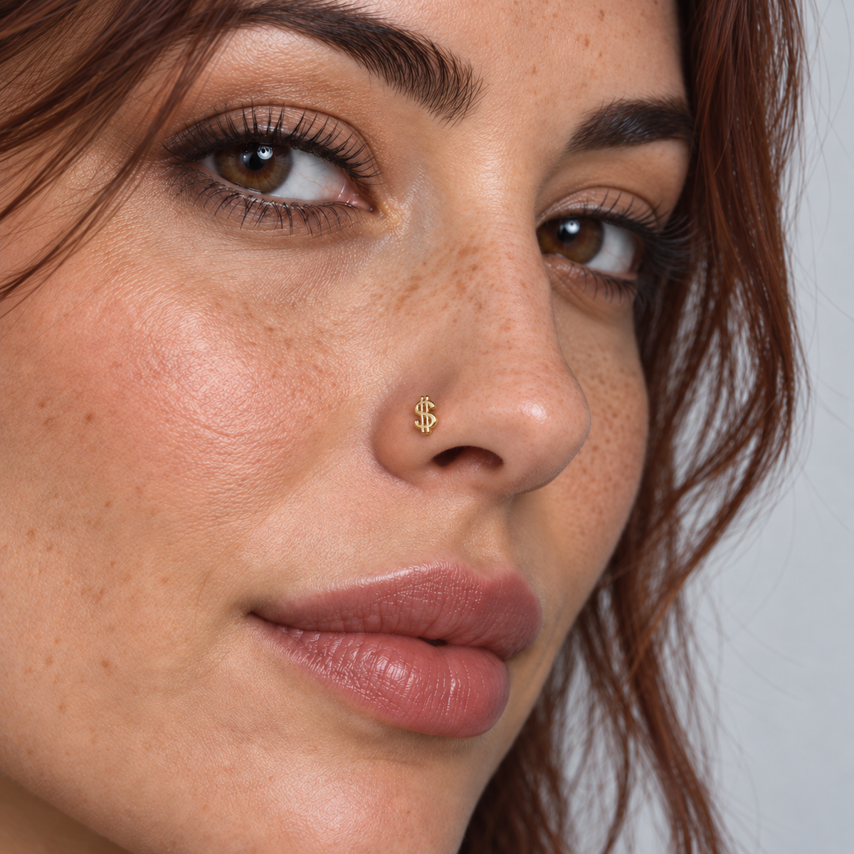 Model wearing a petite gold dollar sign ball tip nose stud