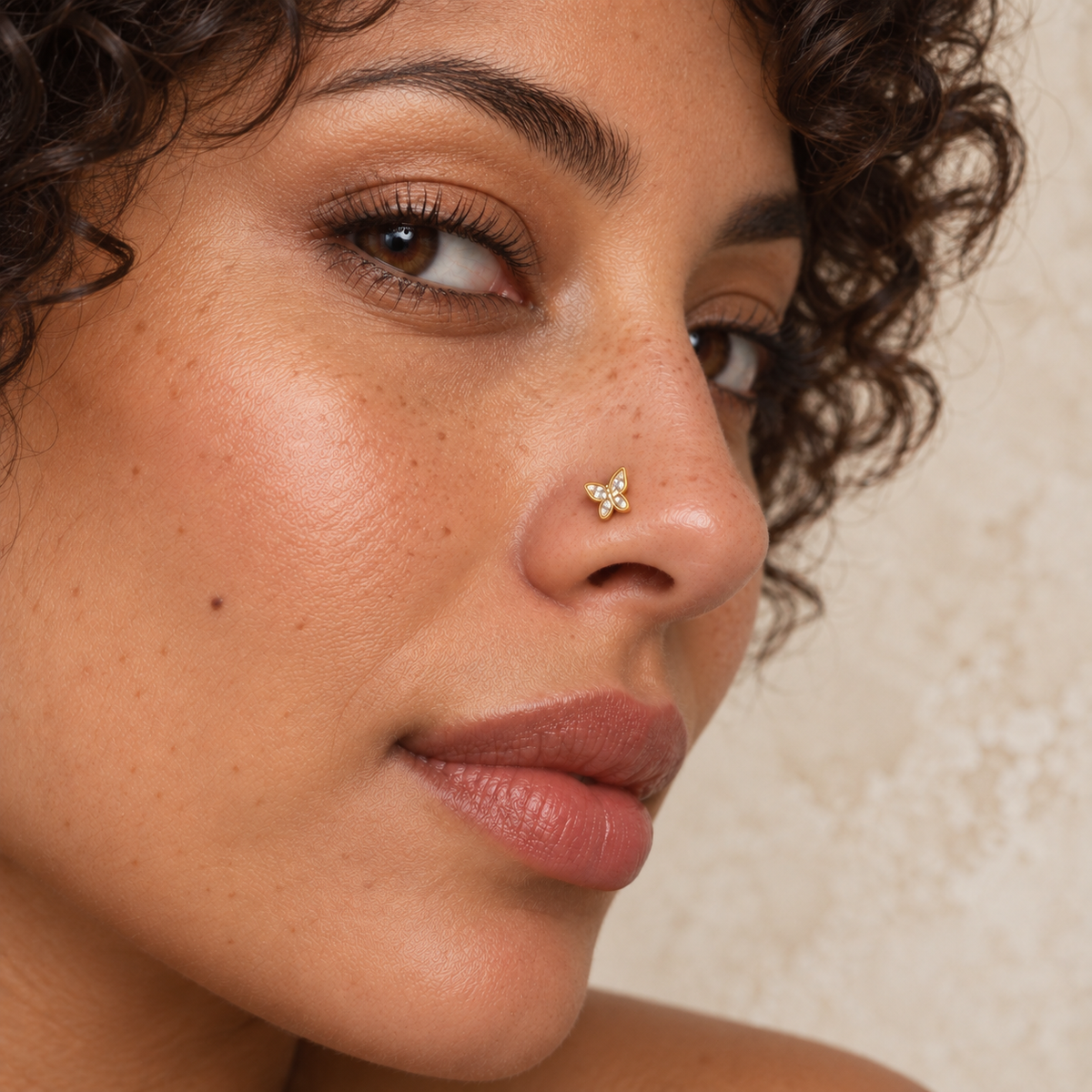 56L small gold crystal butterfly L-shape nose stud worn by curly-haired model