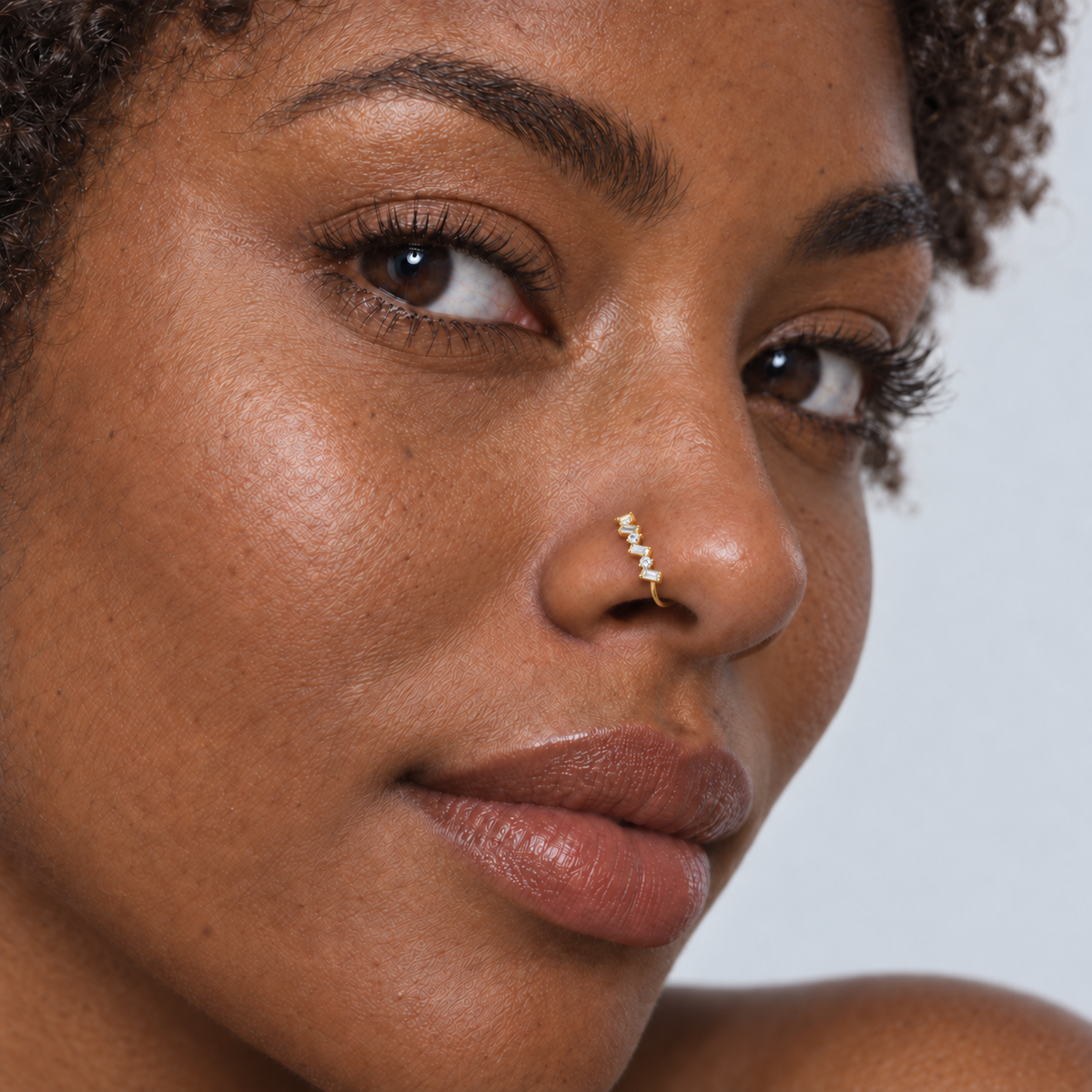 Black model wearing JOAJOA 69 petite gold zigzag crystal clip-on nose ring