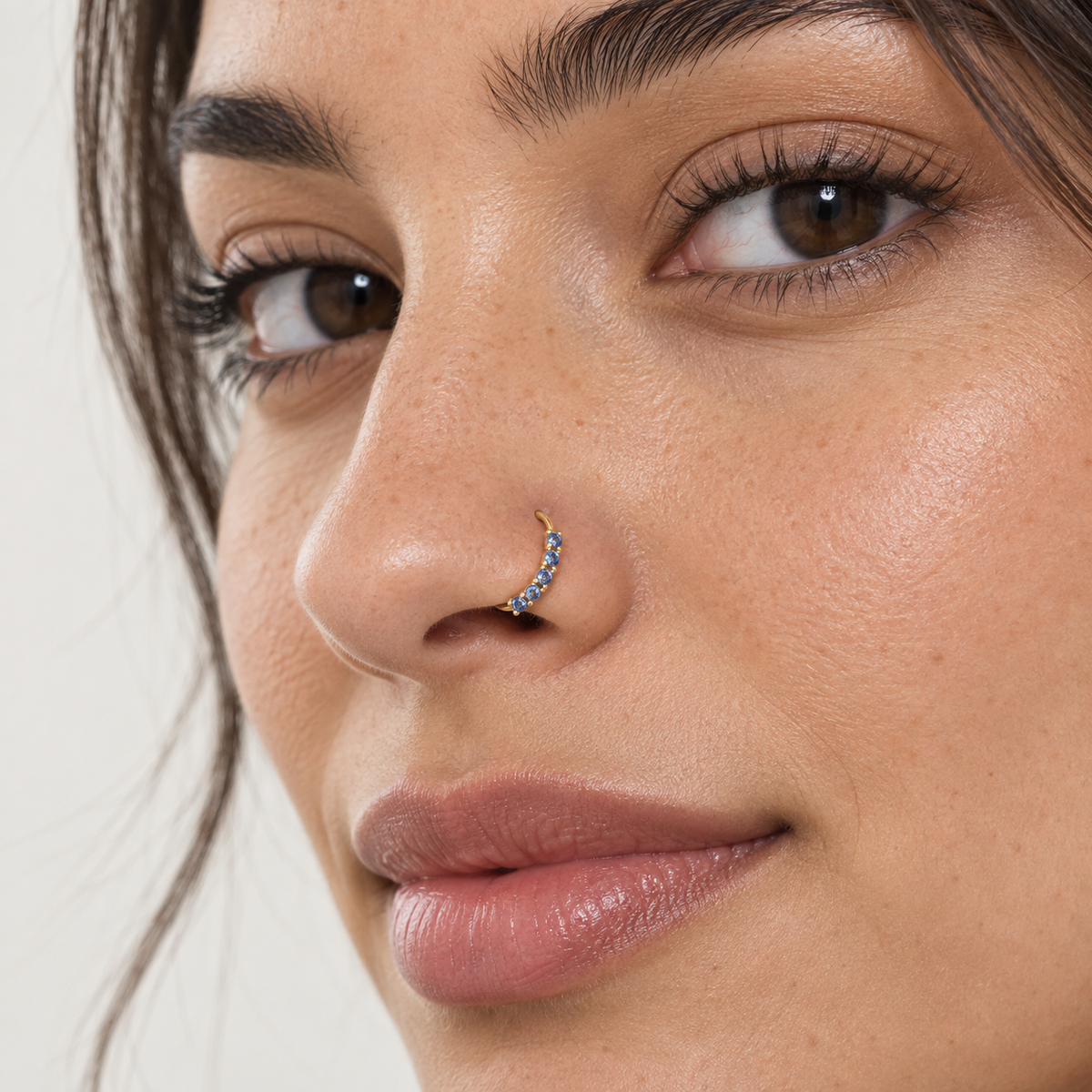 Model wearing JOAJOA 59 gold seven-stone blue crystal hoop nose ring